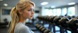 © YudhoStd - Young woman in gym, looking away from the dumbbells rack.