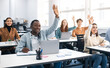 © Prostock-studio - Presentation, Convention Concept. Portrait of smiling international people participating in seminar at modern office, raising hands up to ask question or to volunteer, diverse group sitting at tables