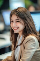 Poster - A woman sits in front of a laptop computer, focused on her work