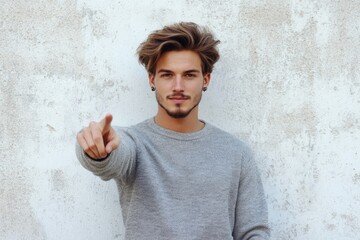 Poster - A person wearing a gray sweater points directly at the camera