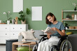 © Pixel-Shot - Young beautiful woman in wheelchair reading book at home