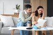 © Pixel-Shot - Worried young couple with bills at home. Bankruptcy concept