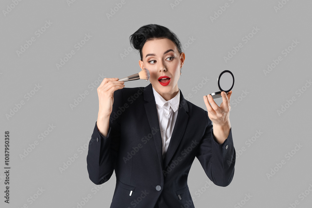 Young pin-up stewardess applying makeup powder on light background