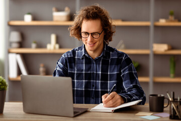 Poster - Successful Businessman At Laptop Computer Writing Taking Notes Sitting At Workplace In Modern Office. Cheerful Employee Making Business Report At Work. Entrepreneurship Career Concept