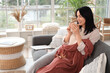 © Pixel-Shot - Beautiful young happy woman with warm plaid and cup of tea sitting on sofa at home
