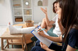 © Pixel-Shot - Young woman with broken leg and doctor sitting on sofa at home
