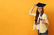© New Africa - Happy student with diploma after graduation on orange background. Space for text
