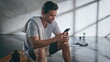 © stockbusters - Smiling sportsman looking mobile phone after training closeup. Guy messaging