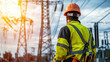 © kongkiat chairat - worker in safety vest and helmet observes power lines at sunset, showcasing importance of electrical engineering and safety in field