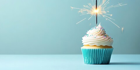Poster - Birthday cupcake with a lit sparkler on a light blue background. Copyspace available.