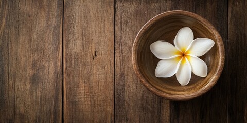 Poster - Camphor in a bowl and a plumeria flower on aged wood, spa ingredient, with copy space.