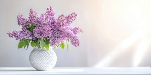 Aufkleber - A vase containing a purple bouquet of lilac flowers on a white table, copyspace.
