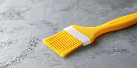 a rubber or silicone pastry brush with a plastic handle is placed on the kitchen table. the apartmen