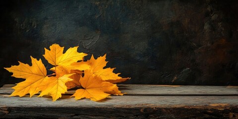 Poster - Autumn still life featuring yellow maple leaves on a wooden surface.