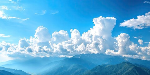Poster - Dramatic landscape - white clouds above the mountain peaks in a blue sky on a sunny day with a copyspace available.