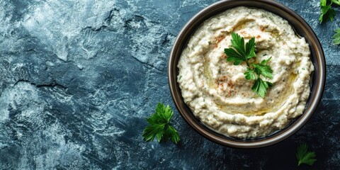 Aufkleber - Baba ganoush (roasted eggplant dip) in a bowl on a blue stone background with free text space. Close-up view.