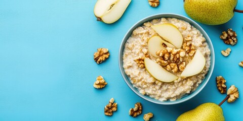 Aufkleber - Healthy breakfast: A bowl of porridge topped with pear slices and walnuts on a blue background. Flat lay. Copy space. Top view.