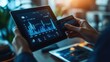 © Thirawat - A business person holding a credit card close to a tablet, displaying a financial graph.
