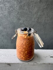 a glass jar with chocolate overnight oats with blueberries