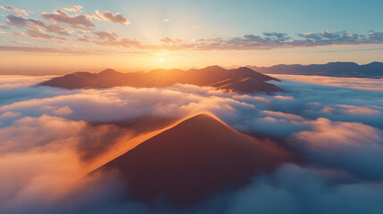 Drone shot capturing sand dunes enveloped in thick fog as the sunrise paints the sky in warm hues creating a surreal serene and mystical landscape with golden light filtering through the mist