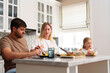 © fotofabrika - A family enjoys a meal together at a kitchen island