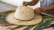 © Thanawat_Suesoypan - Crafting a traditional straw hat with palm leaves