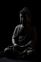 Wall Mural - Meditating Buddha Statue on dark background. Soft focus. Close up. Copy space.	