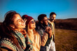 © Zoran Zeremski - Smiling group of friends having fun while hiking together on hill at sunset.