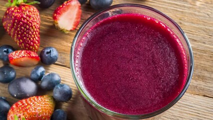 Wall Mural - Glass of beetroot and berry boost juice sitting on rustic wooden table