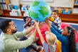© Rido - Happy multiethnic children holding planet earth globe at school