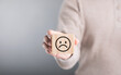 © SKT Studio - Man holds a wooden block with a sad face, symbolizing feelings of sadness or emotional challenges. This image reflects the concept of acknowledging and addressing negative emotions