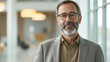 © CanvasVoyager - A middle-aged man with a salt-and-pepper beard, wearing glasses and a casual blazer, standing confidently, high-quality, clear-focus.