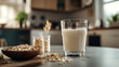 © Lalida - A refreshing glass of oat milk next to a bowl of oats, perfect for a healthy breakfast in a modern kitchen.