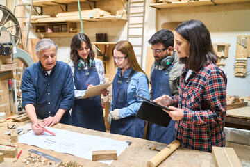 Wall Mural - Teamwork and apprenticeship in a busy lumberyard workshop