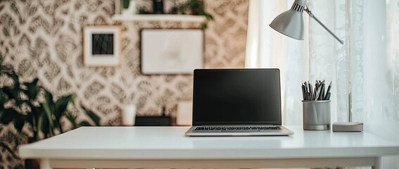 Poster - A workstation with a laptop, and desk lamp on a white table in a minimalist interior with a patterned wallpaper wall