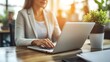 © C - Modern home office scene featuring a focused individual in a comfortable chair,utilizing laptop an web camera for remote hiring success,accompanied by natural lighting ,potted plant decor,and spacious