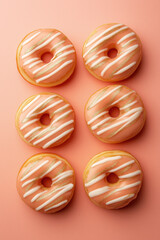 Wall Mural - collection of six freshly glazed donuts with peach color and white stripes arranged neatly on a solid background