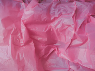 Wall Mural - pink wrinkled plastic texture for a pastel background.
