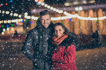 Wall Mural - Photo of two sweethearts pair in love attending city park at newyear midnight frosty weather standing close wearing warm winter jackets outdoors