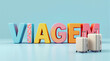 © Marcelo - A imagem apresenta a palavra 'VIAGEM' em letras coloridas e tridimensionais, acompanhada por malas de viagem em um fundo azul claro.