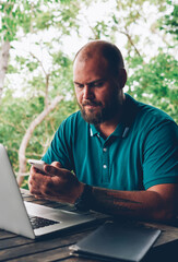 Fototapete - serious hipster guy making payment for salad on lunch using banking application on smartphone, man f