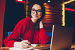 © BullRun - Smiling young woman enjoying freelance work in cafe interior making notes of ideas in notepad, positive female student doing homework in good mood satisfied with wifi for learning on laptop computer