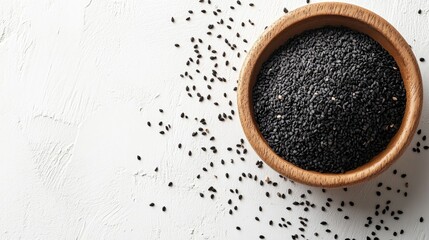 Black sesame seeds in a wooden bowl with scattered seeds on a textured white background, showcasing their rich color and natural oils.