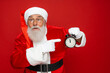 © InsideCreativeHouse - Look attention! Wee can miss festive event party! Worried terrified stressed Santa in costume gloves headwear stylish spectacles show finger forefinger on deadline limit timer isolated red background