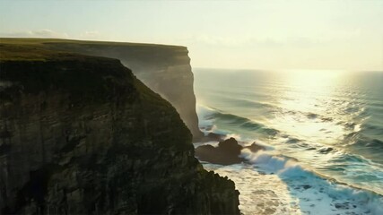 Wall Mural - Ocean Cliff Sunset: Dramatic coastal landscape photo of a steep cliff face meeting powerful ocean waves during a vibrant sunset.  The sun's golden light illuminates the scene.