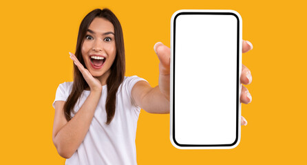 Aufkleber - Wow, Amazing Useful App. Portrait of excited and surprised young woman holding smartphone with black blank screen in hand, showing device, closeup. Gadget with empty free space for mock up template