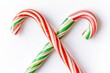 Red and green striped candy canes crossed on white