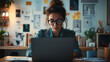 © dK - A woman focused on UX design on a laptop in a creative workspace