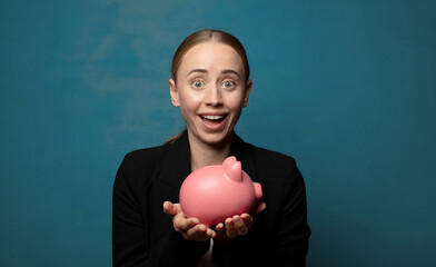 Wall Mural - young blonde woman with a piggy bank