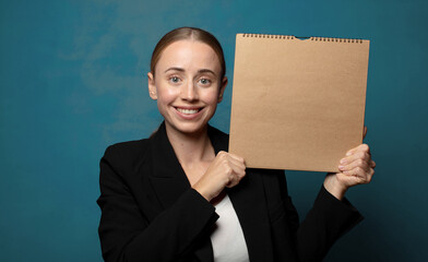 Wall Mural - young blonde woman with a paper notebook